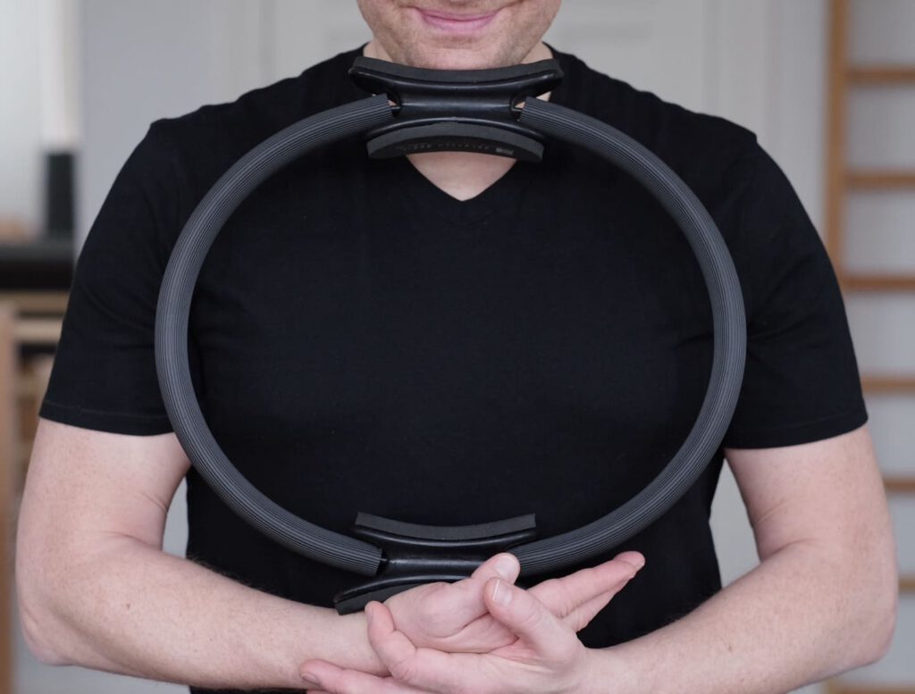 Das Foto zeigt Christian Dorn, der Pilatestrainer bei 'Powerhouse Pilates Studio', mit dem Kleingerät Magic Circle.